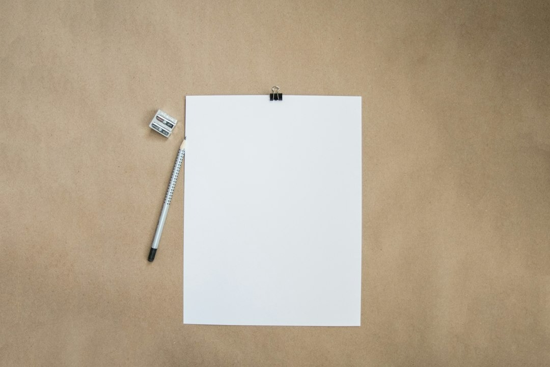 White paper held by binder clip with pencil and sharpener.